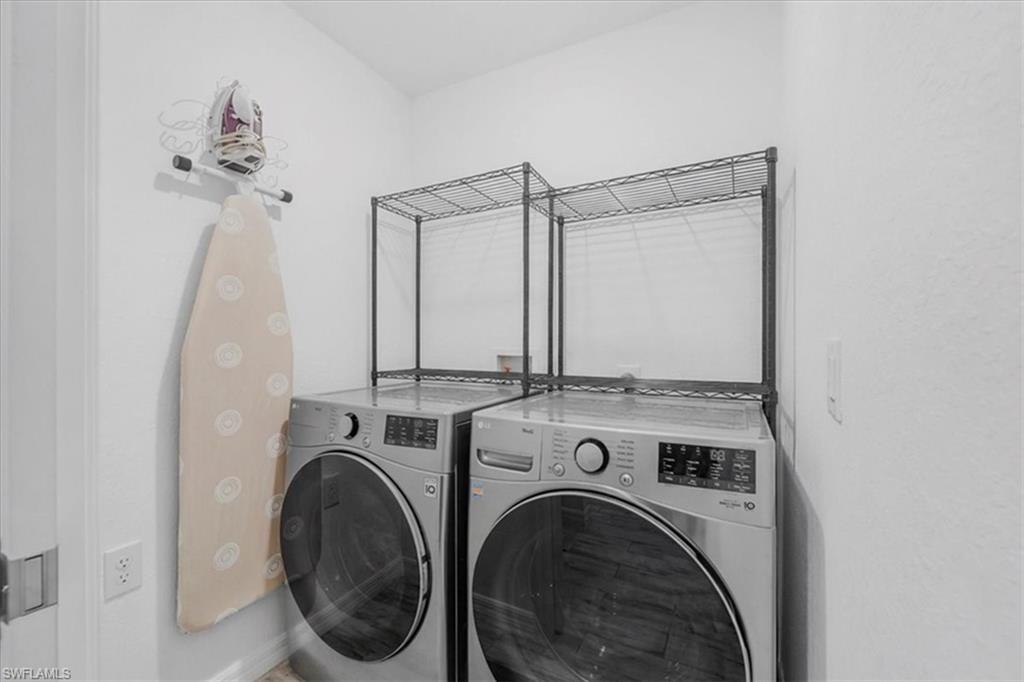 Laundry area featuring washer and dryer and baseboards