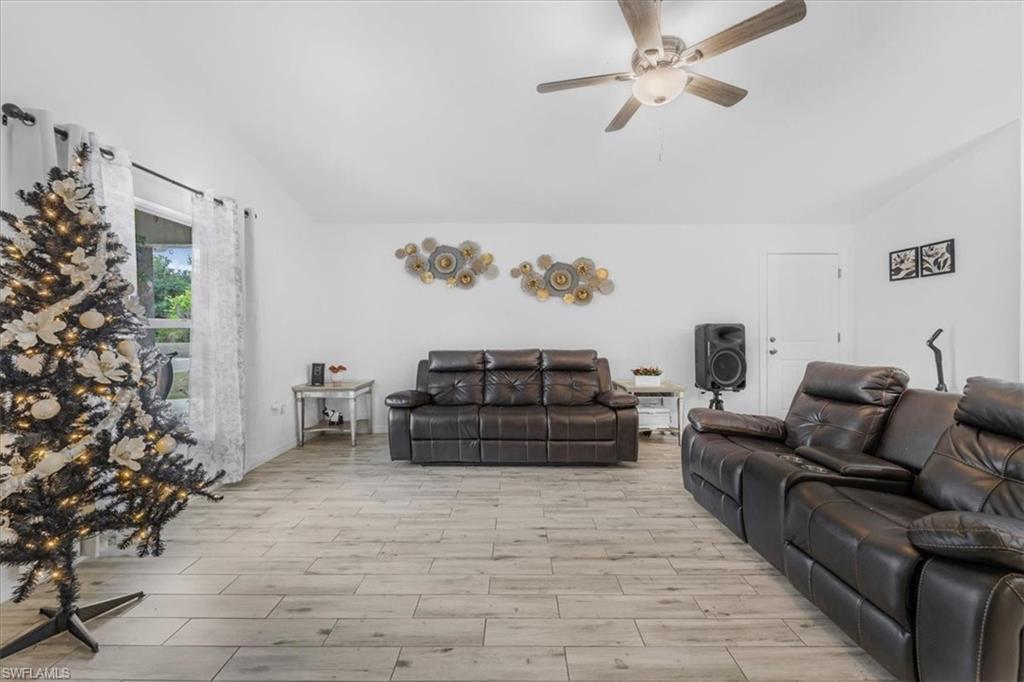 Living area featuring lofted ceiling, ceiling fan, and wood finished floors