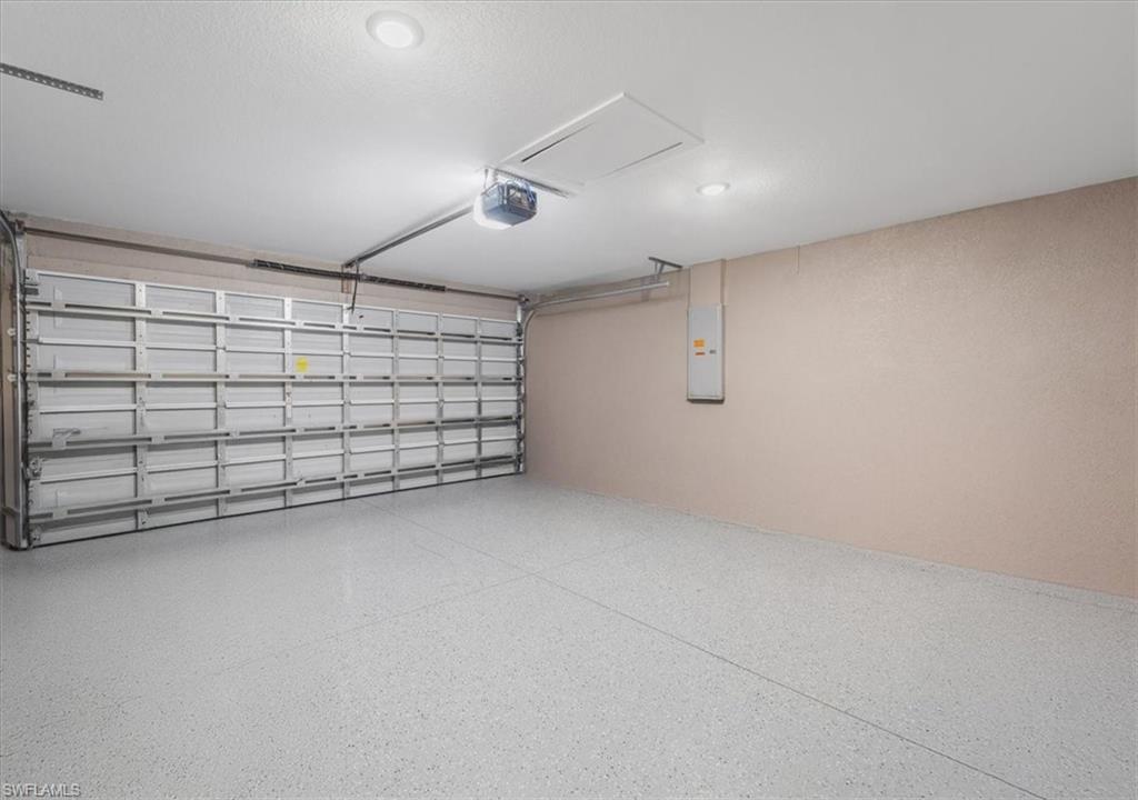 Garage featuring electric panel and a garage door opener