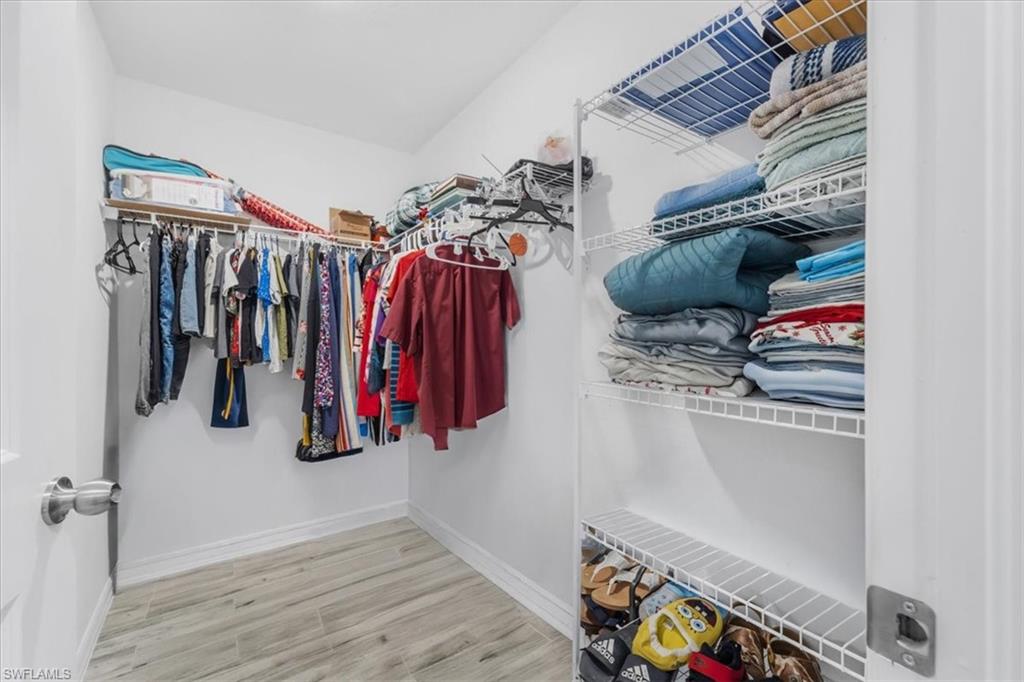 Walk in closet with light wood-style floors