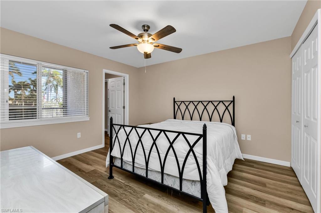 Bedroom with a closet, light wood-style flooring, and a ceiling fan