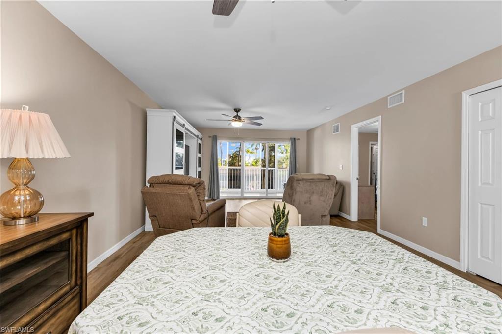 Dining area featuring a ceiling fan and dark wood-style flooring