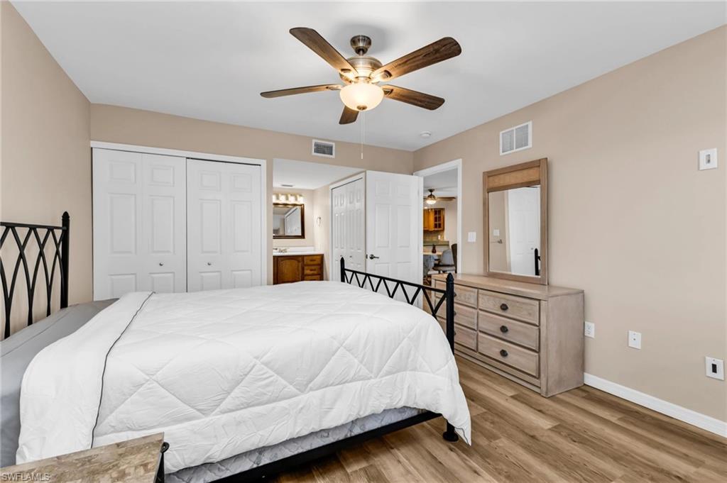 Bedroom with multiple closets, light wood-style flooring, and a ceiling fan
