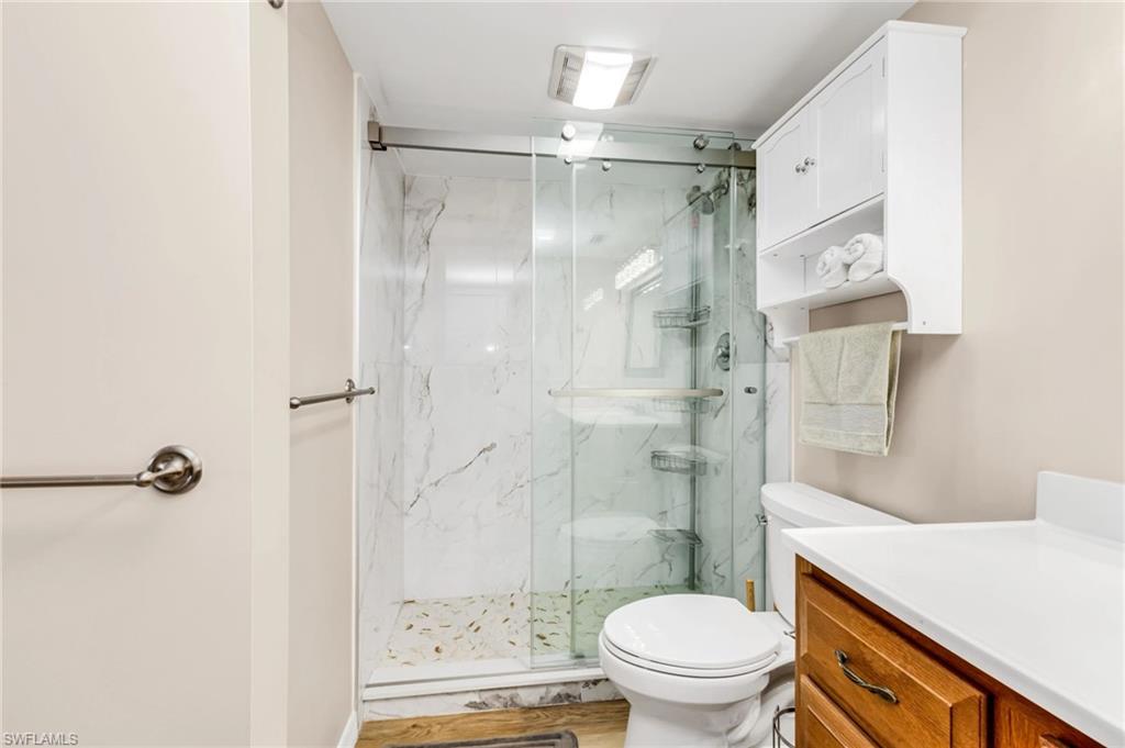 Bathroom featuring vanity and a marble finish shower