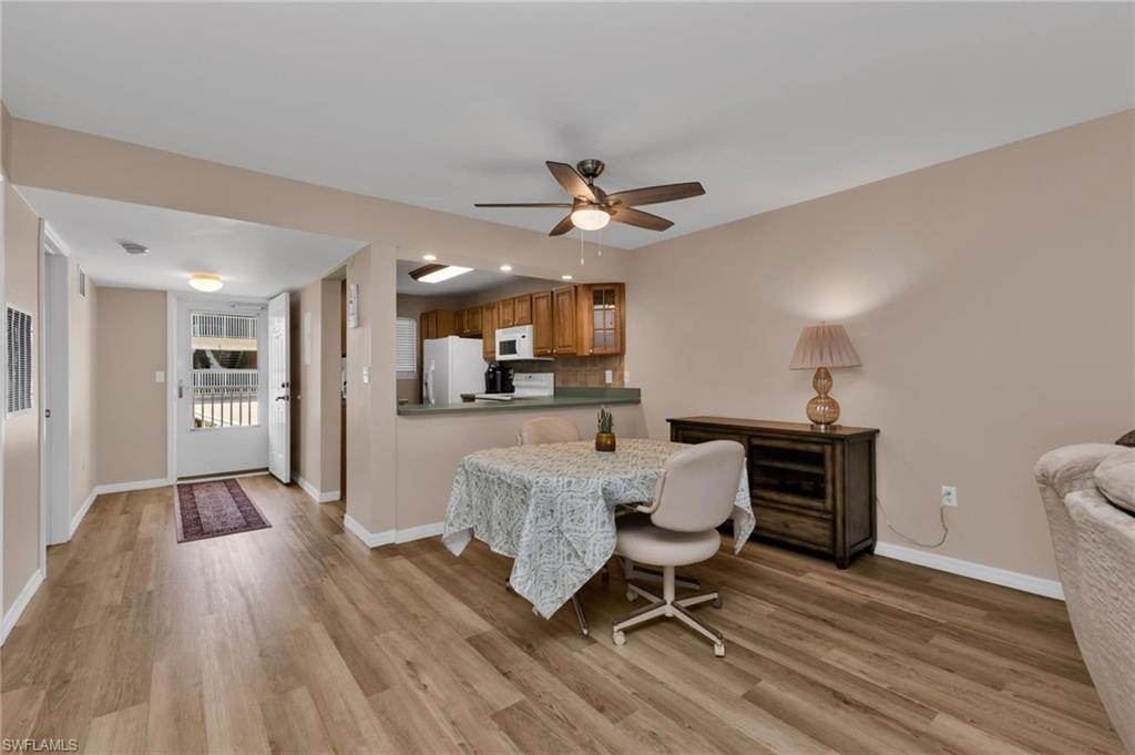 Dining area with a ceiling fan and light wood-type flooring