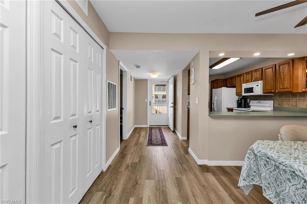 Kitchen with wood finish cabinetry, white appliances, ceiling fan, light wood finished floors, and recessed lighting