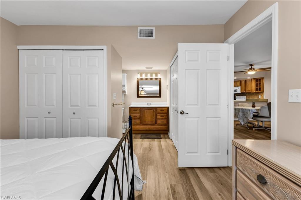 Bedroom with light wood-style floors and multiple closets