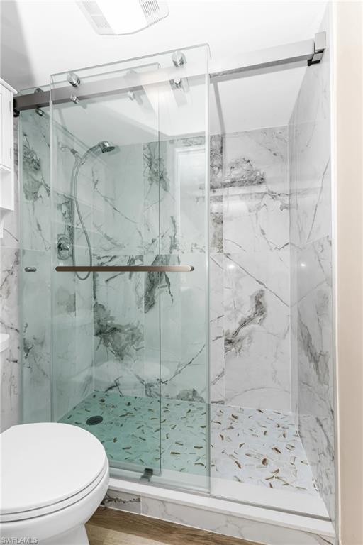 Full bathroom with a marble finish shower