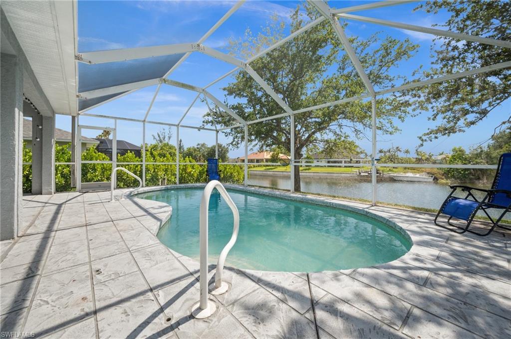Outdoor pool with a lanai, a sunroom, a patio area, and a water view
