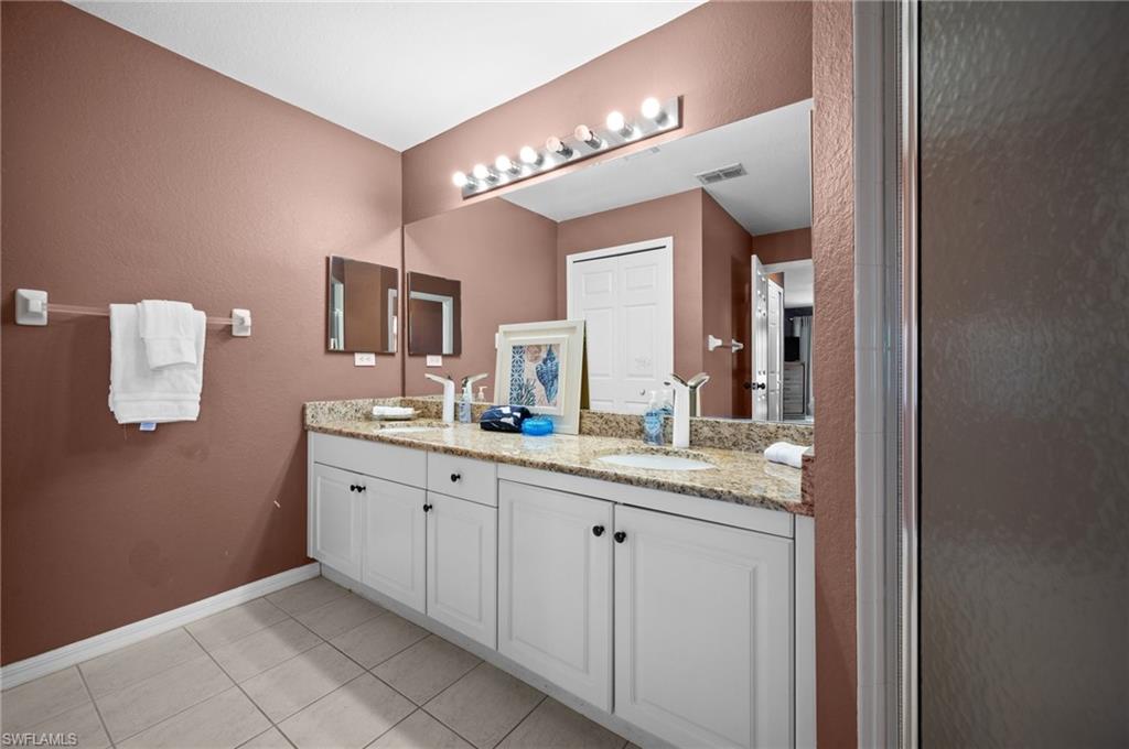 Full bathroom with double vanity and light tile patterned flooring
