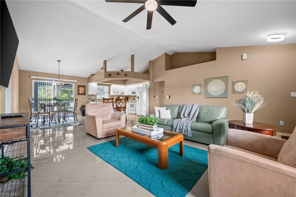 Tiled living area featuring a high ceiling and ceiling fan