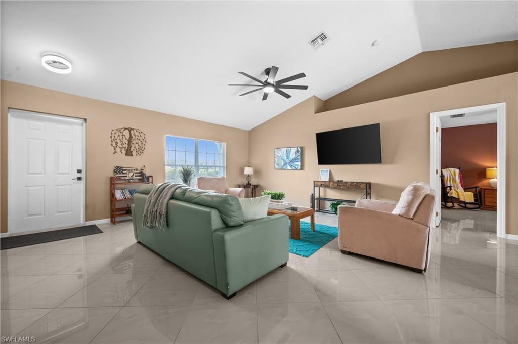 Living room with lofted ceiling and ceiling fan