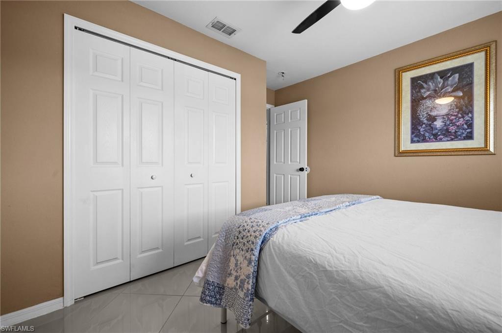 Bedroom featuring ceiling fan, a closet, and tile patterned flooring