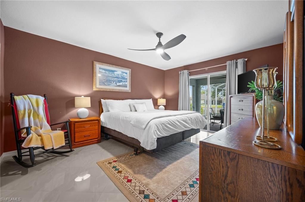 Bedroom with access to exterior, a ceiling fan, and light tile patterned floors