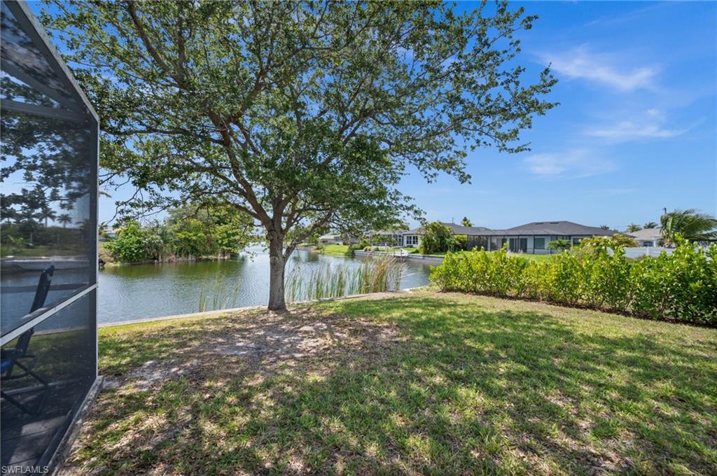 View of green lawn featuring a water view