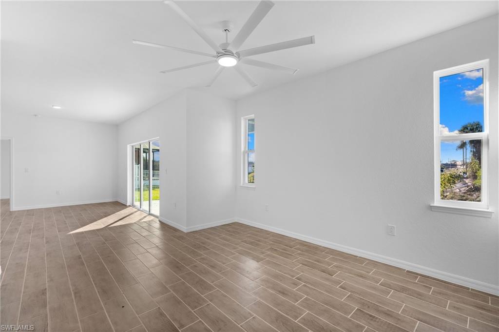 Spare room with wood finish floors, a ceiling fan, and recessed lighting