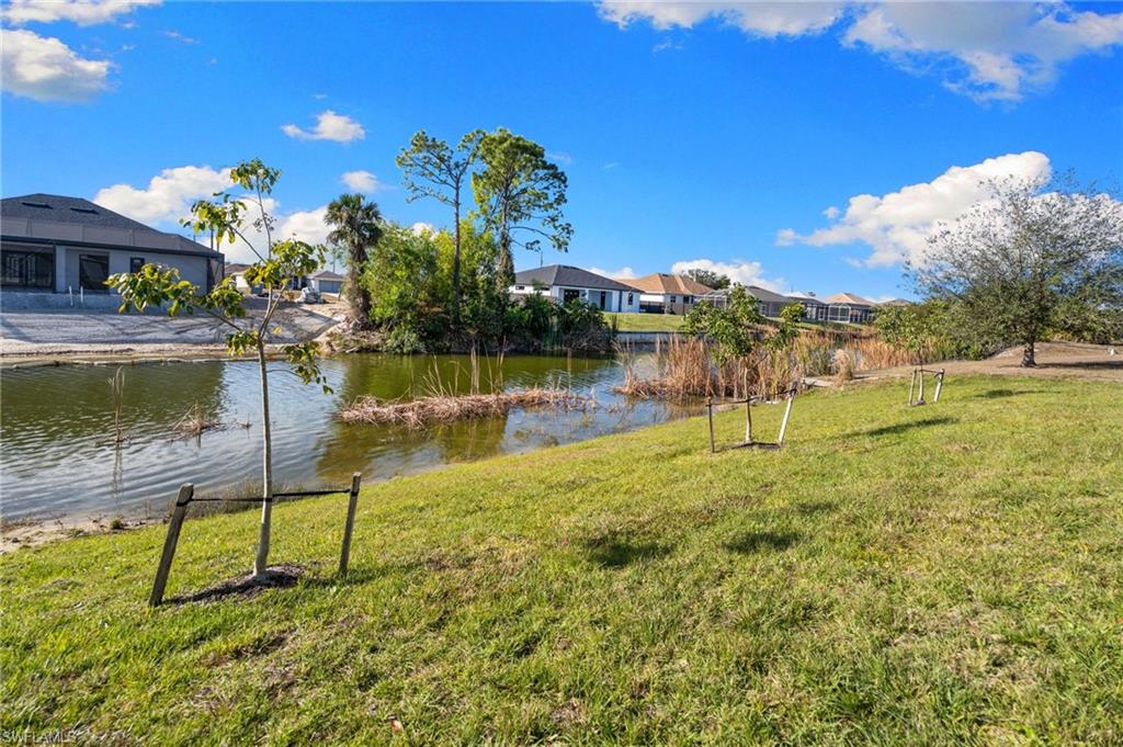 View of green lawn with a water view and a residential view