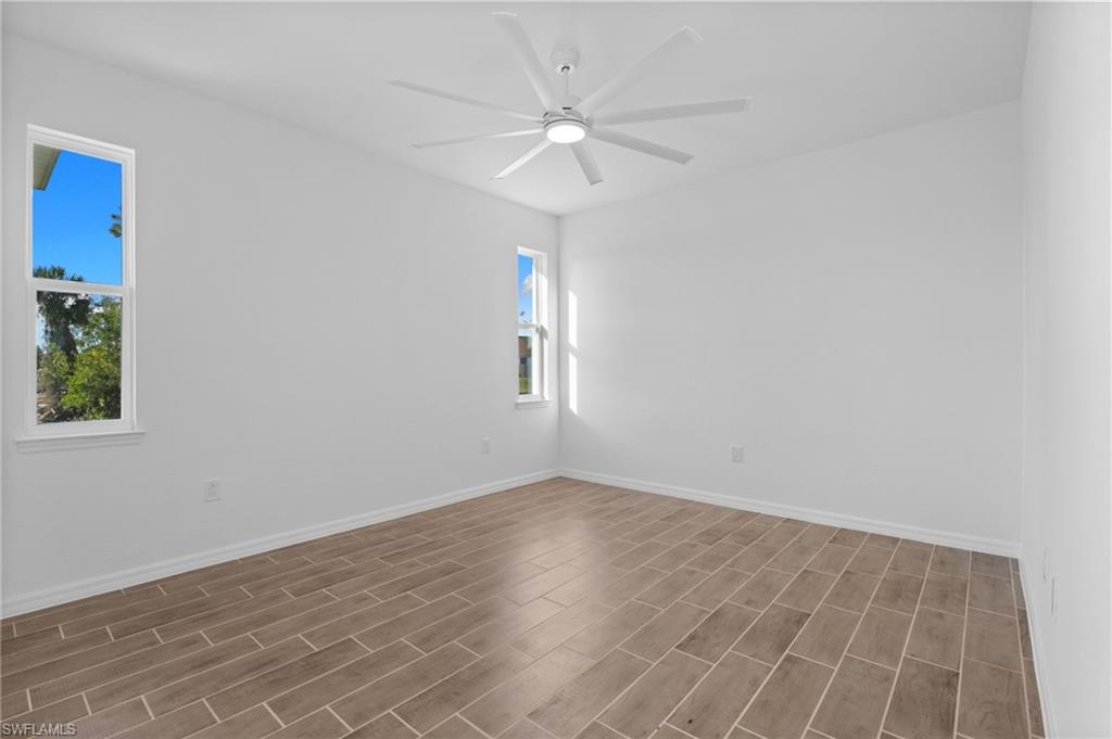 Empty room featuring wood finish floors and a ceiling fan