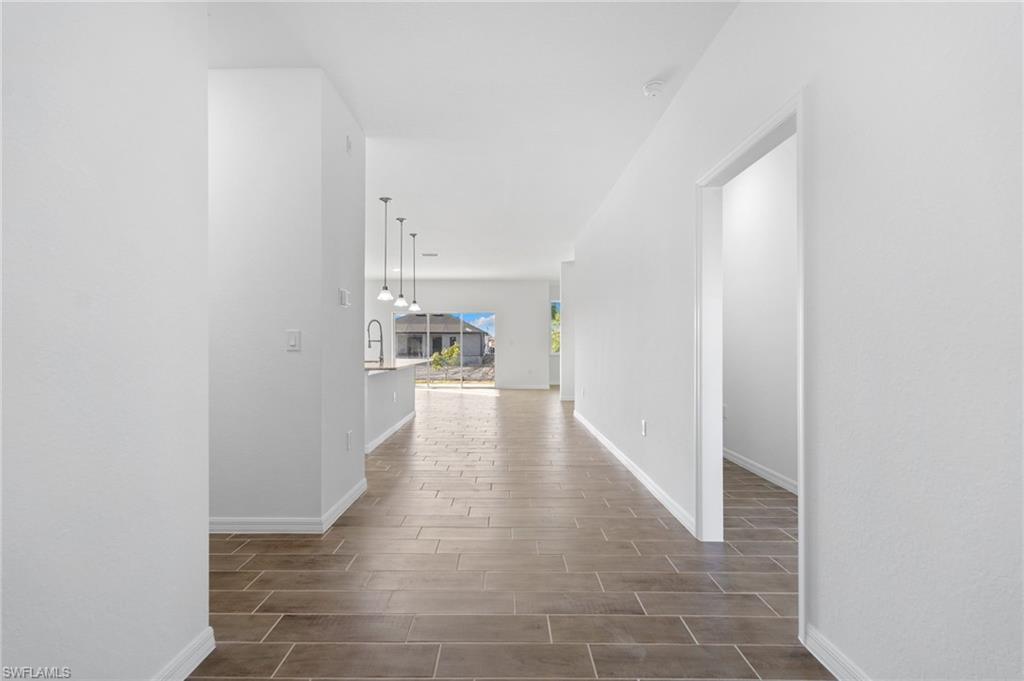 Hall with baseboards and wood finish floors