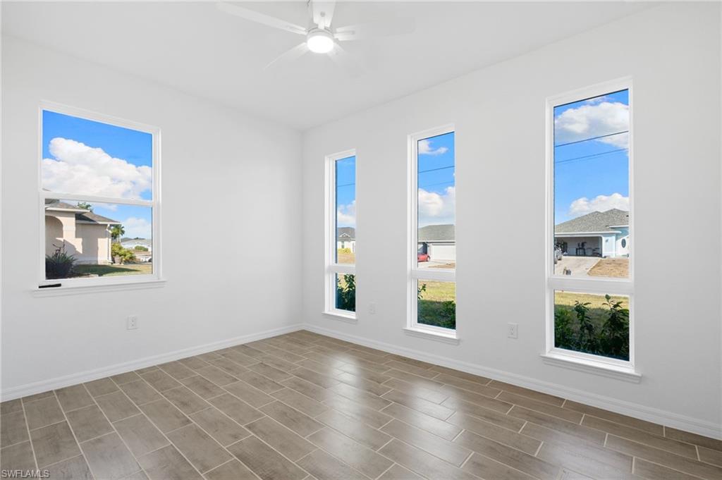 Unfurnished room featuring wood tiled floors and a ceiling fan