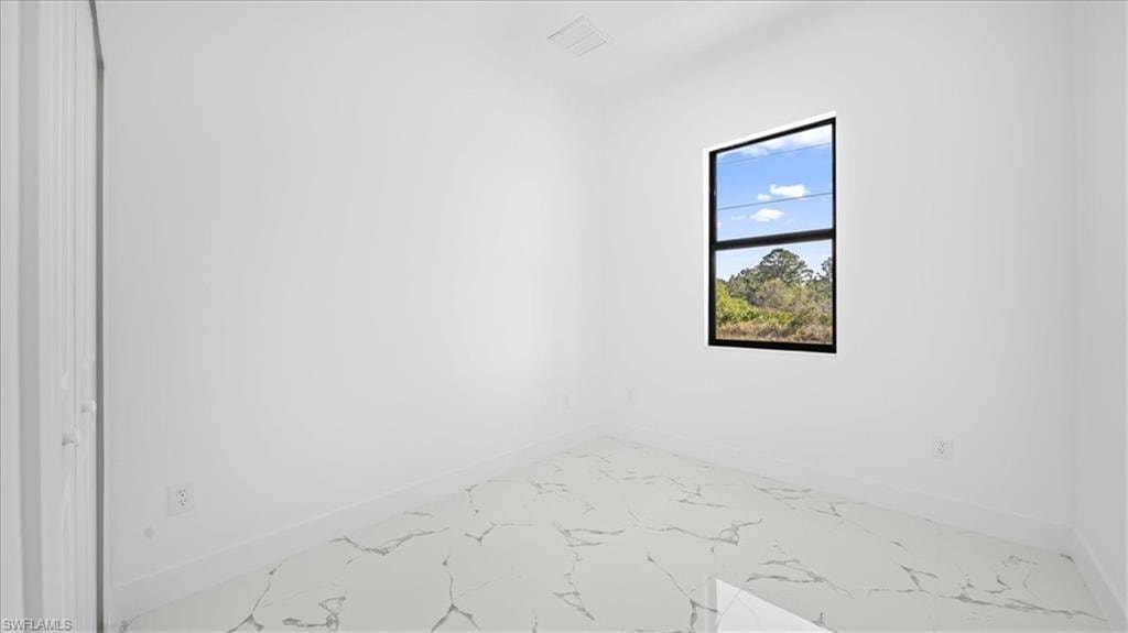 Spare room with baseboards and light marble finish flooring