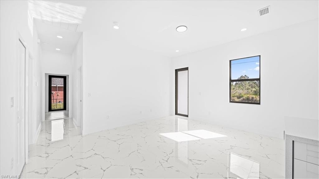 Spare room featuring light marble finish flooring and recessed lighting