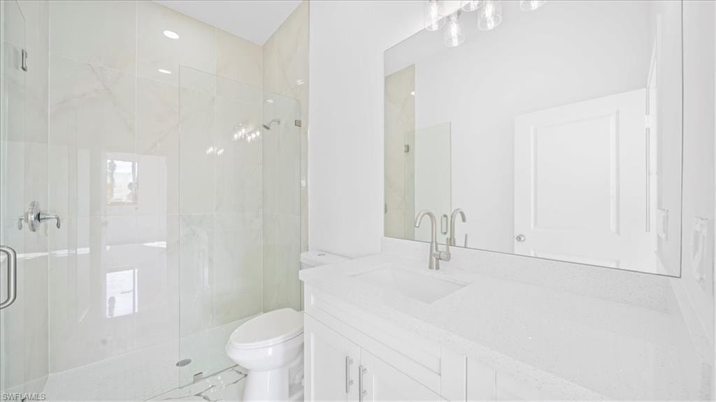 Bathroom featuring a marble finish shower and vanity