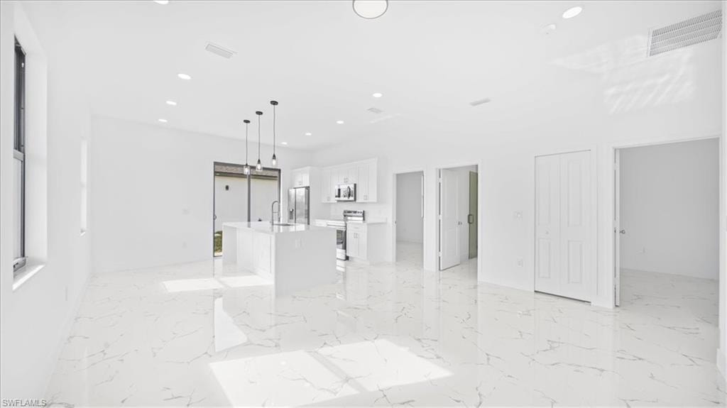 Unfurnished living room featuring recessed lighting and a sink