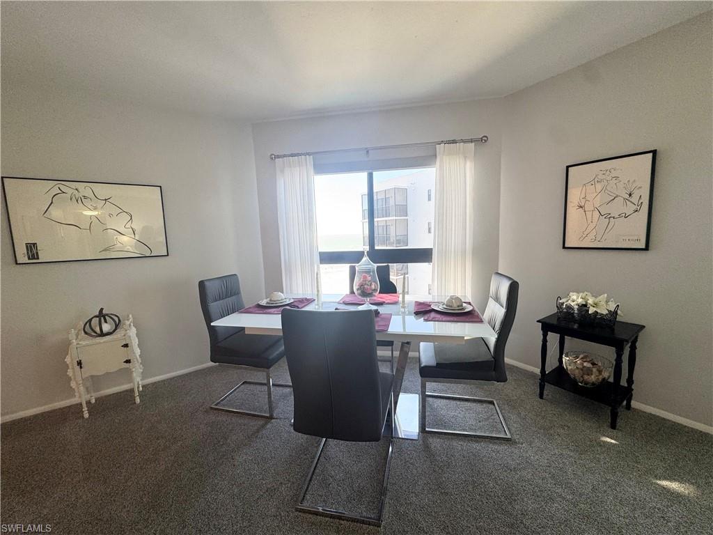 Dining space featuring  carpet and baseboards with views out to the Gulf of Mexico