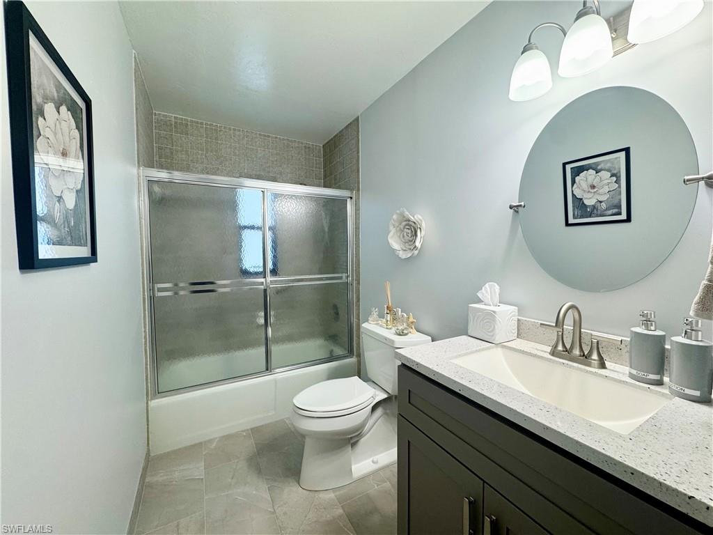 Guest Bathroom with vanity and combined bath / shower with glass door