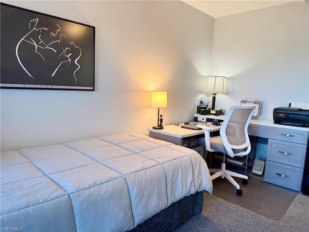 Carpeted bedroom featuring a desk