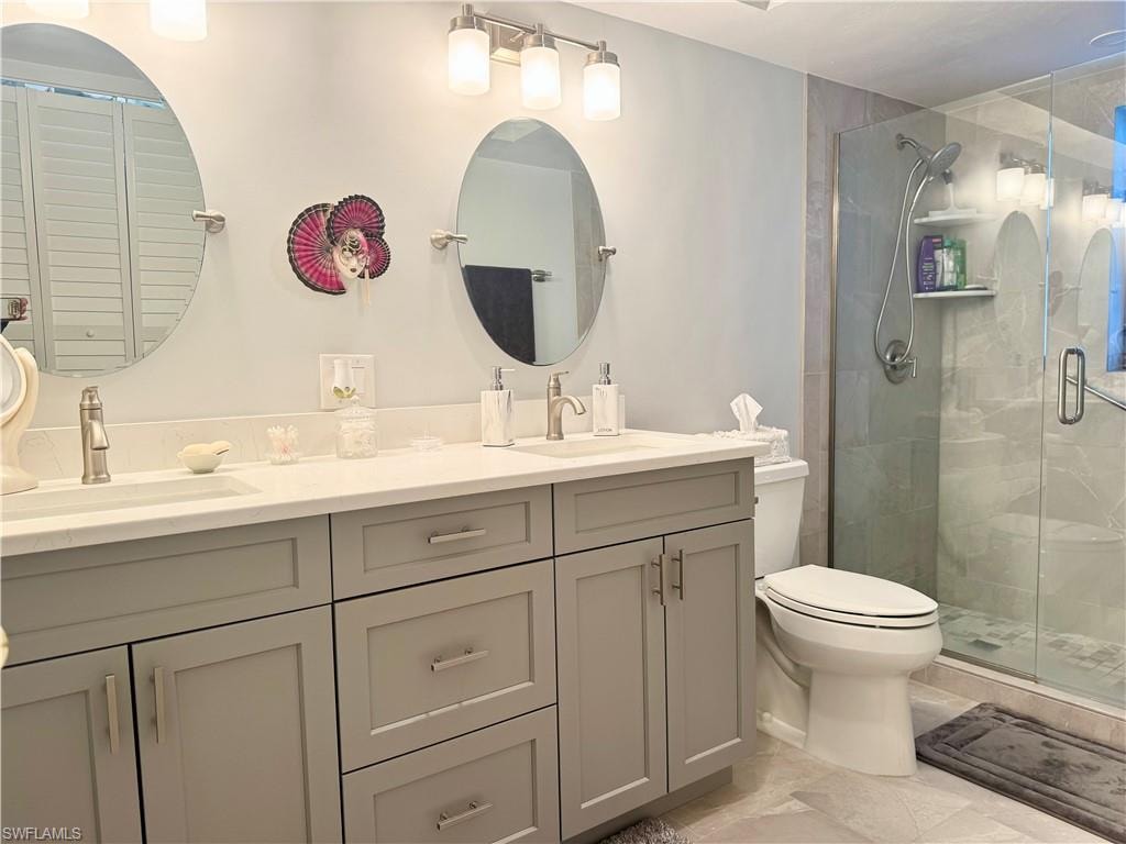 Bathroom featuring double vanity and a stall shower