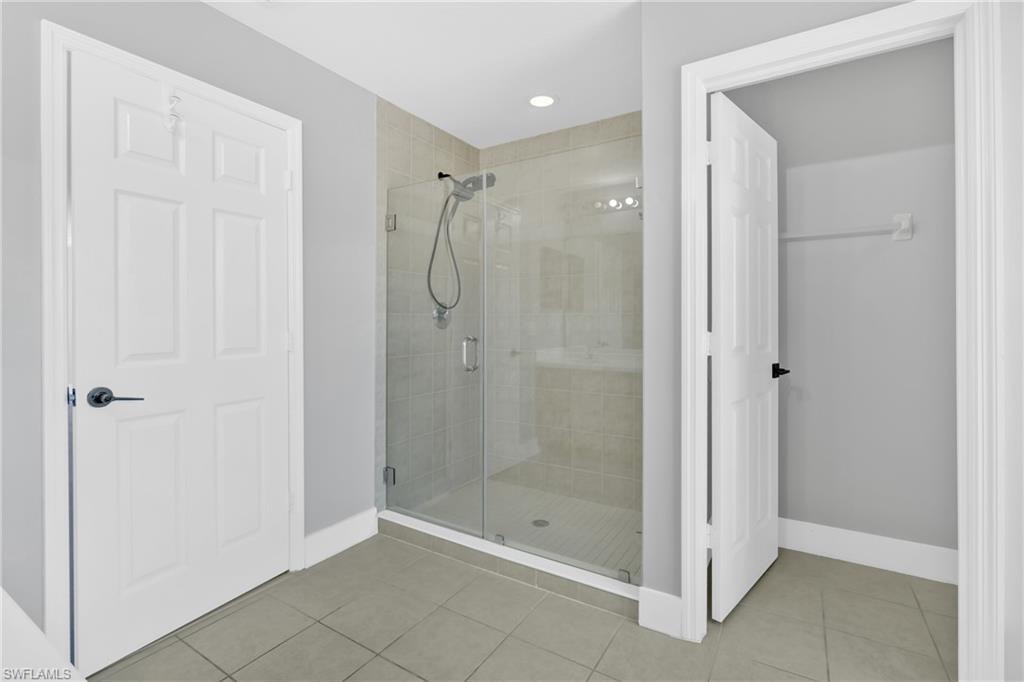 Bathroom with a stall shower, light tile patterned floors, and recessed lighting