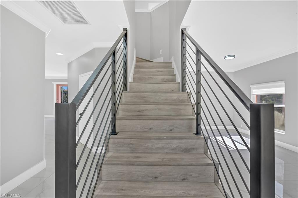 Stairway featuring crown molding, healthy amount of natural light, and recessed lighting