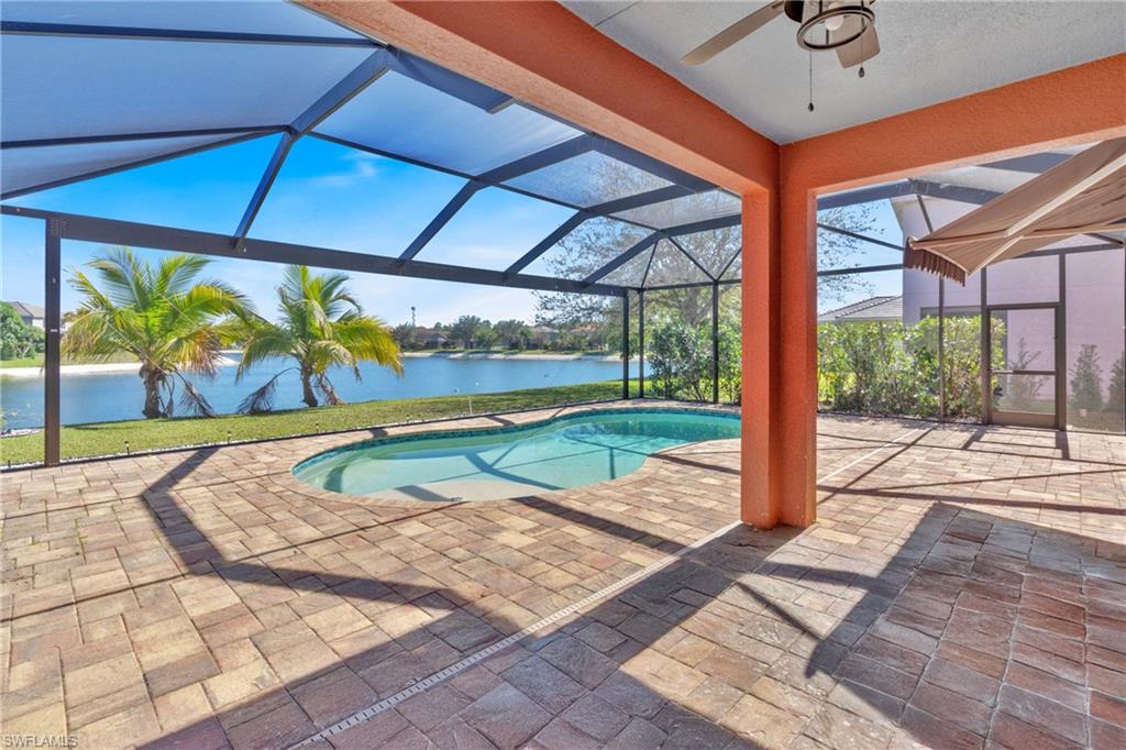 Swimming pool with a patio, a lanai, a sunroom, and a water view
