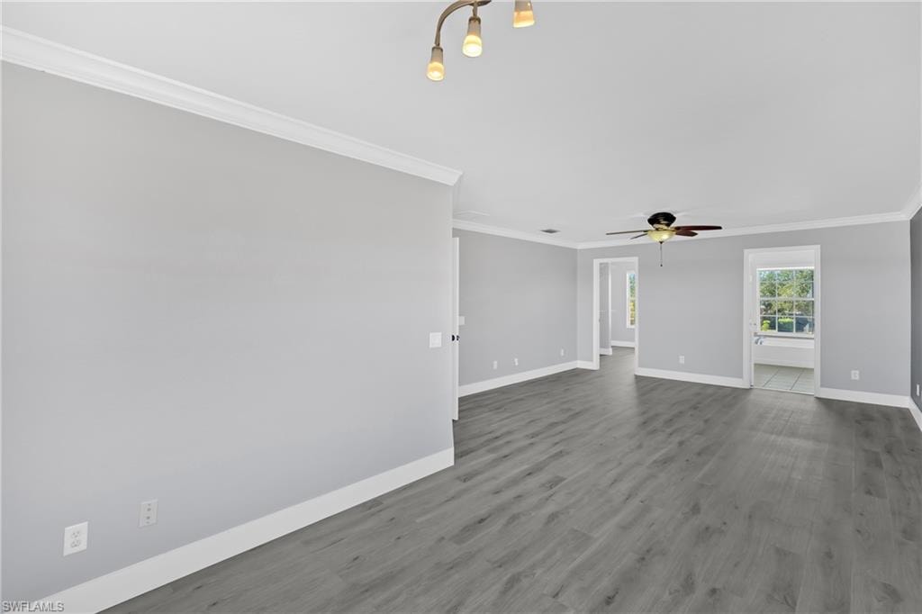 Spare room featuring ornamental molding, wood finished floors, and a ceiling fan
