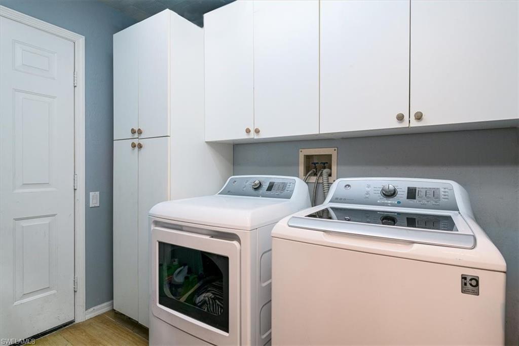 Spacious Laundry Room with white cabinetry for storage
