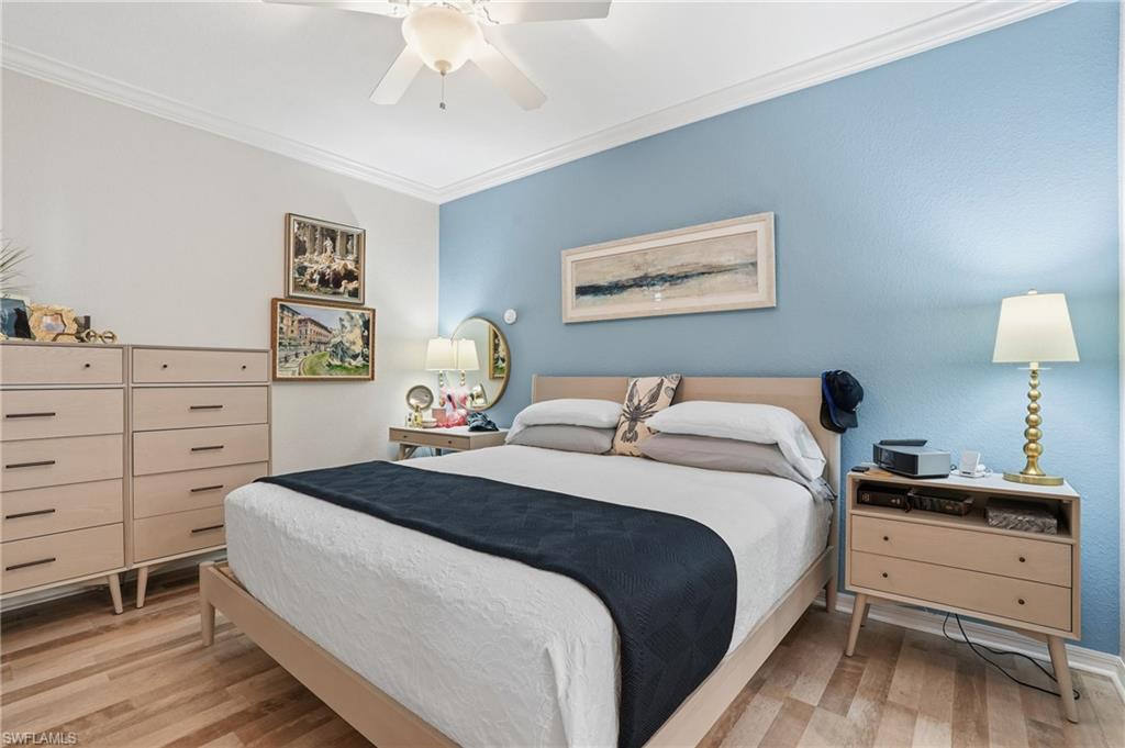 Bedroom with ornamental molding, light wood finished floors, and ceiling fan