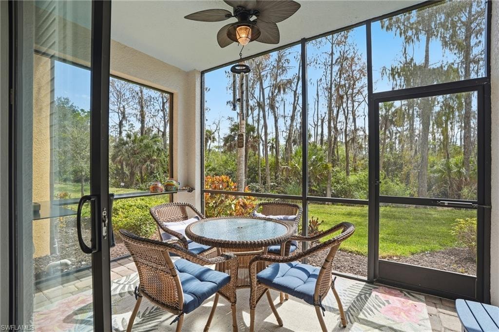 Sunroom featuring outdoor dining space, a ceiling fan, and healthy amount of natural light
