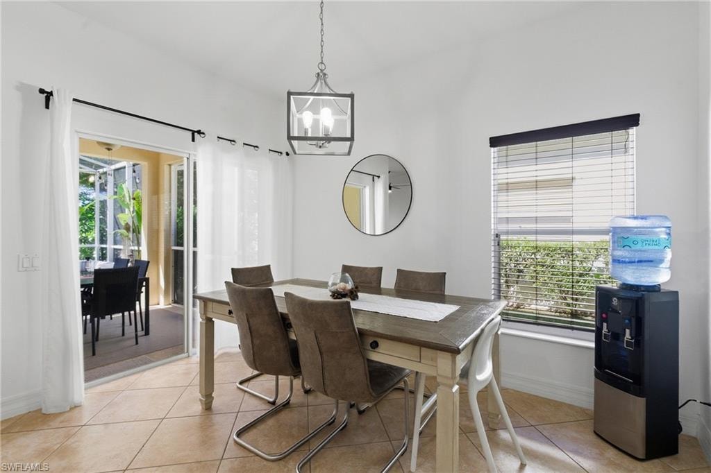 Dining area featuring light tile patterned flooring and suspended lighting