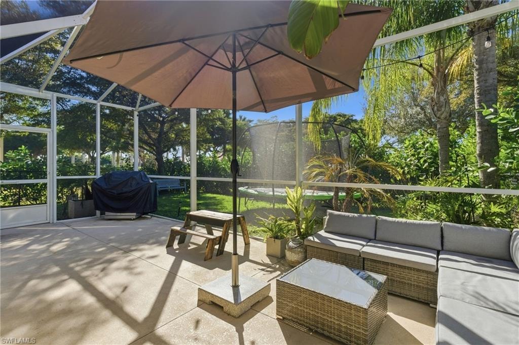 View of patio / terrace featuring a grill, glass enclosure, an outdoor lounge area, and a sunroom