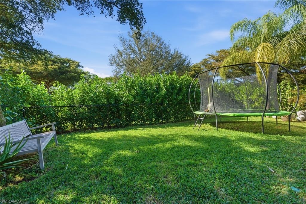Fenced backyard with a trampoline