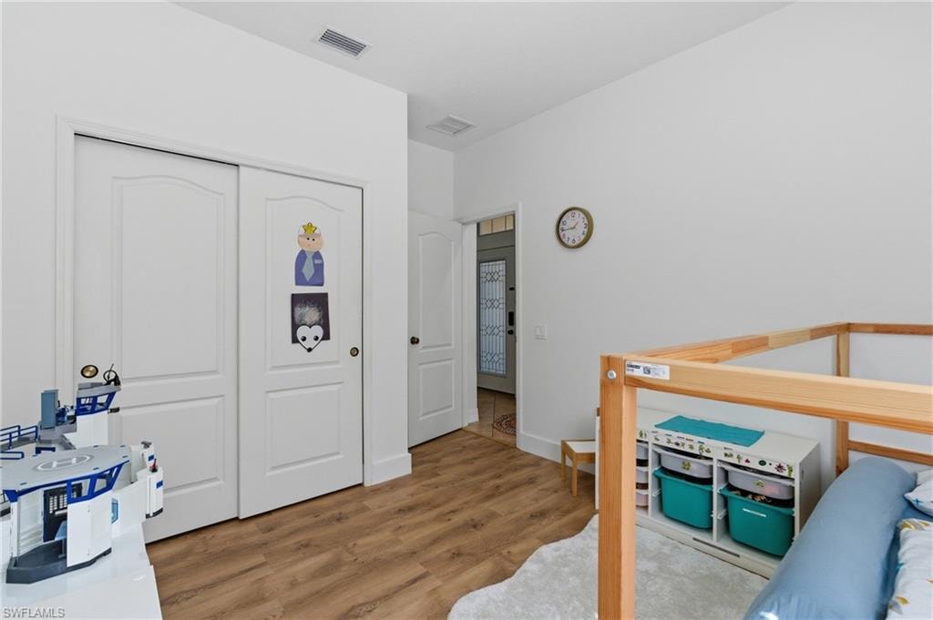 Bedroom featuring light wood-style flooring and a closet