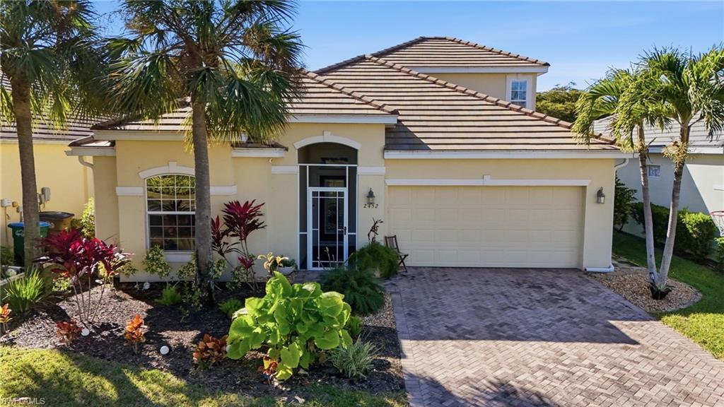 Mediterranean / spanish house featuring a garage, decorative driveway, stucco siding, and a tiled roof