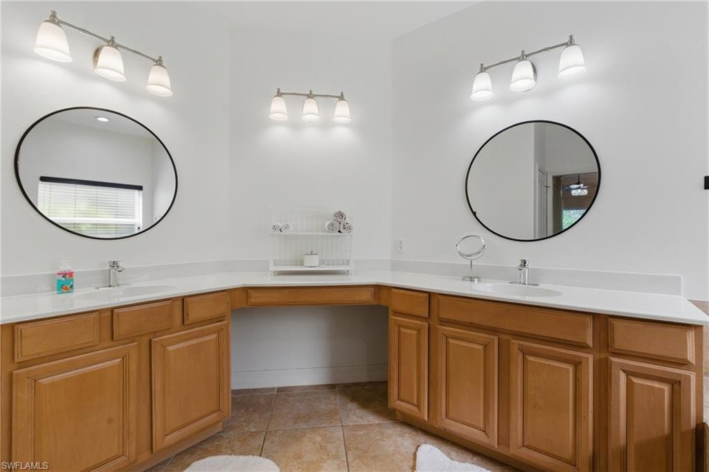 Full bathroom with double vanity and light tile patterned flooring