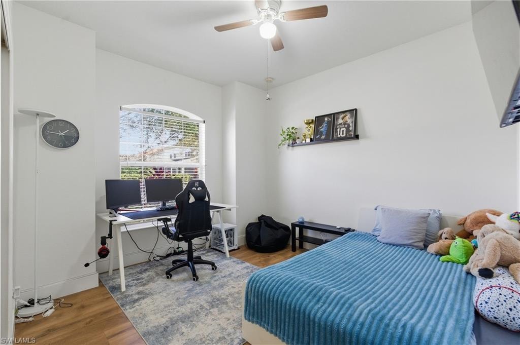 Bedroom with a desk, wood finished floors, and ceiling fan