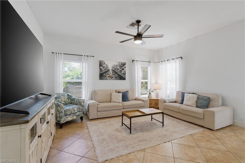 Living room featuring light tile patterned floors and a ceiling fan