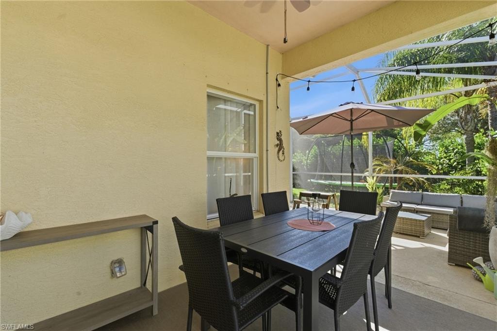 View of patio with a lanai, a sunroom, outdoor lounge area, and ceiling fan
