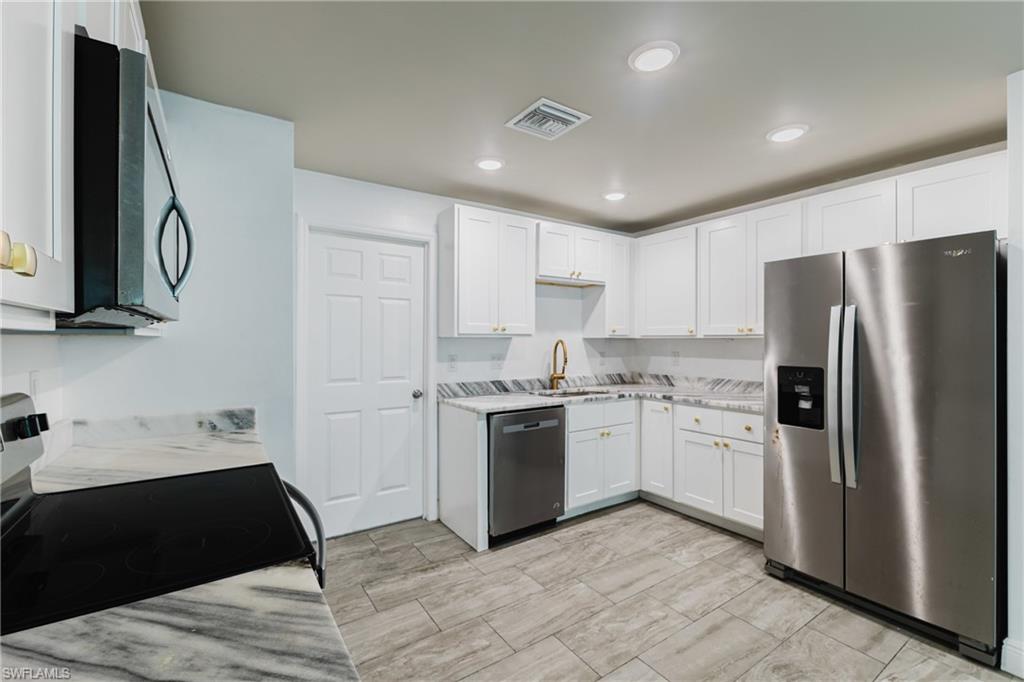 Kitchen with stainless steel appliances, white cabinets, and recessed lighting