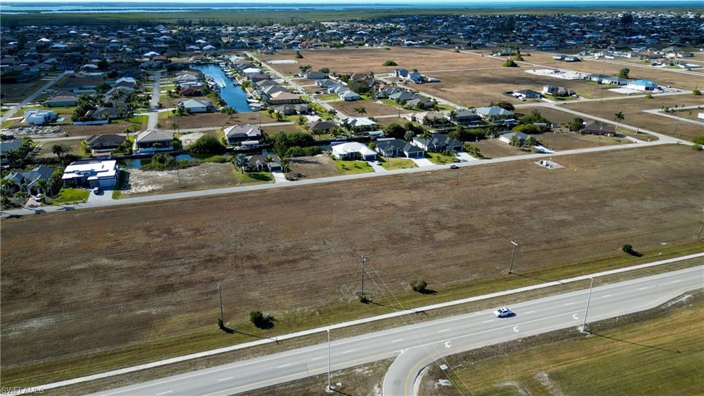 Aerial view of property and surrounding area with nearby suburban area